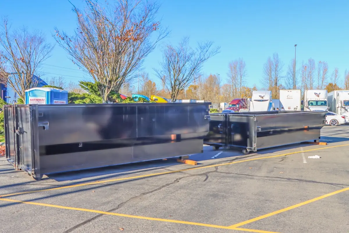 Professional dumpster rental service with roll-off container on residential driveway in Noble